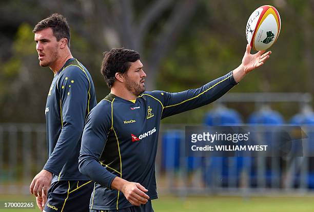Australian Wallabies fullback Adam Ashley-Cooper catches a ball as teammate lock Kane Douglas looks away during a team training session in Sydney on...
