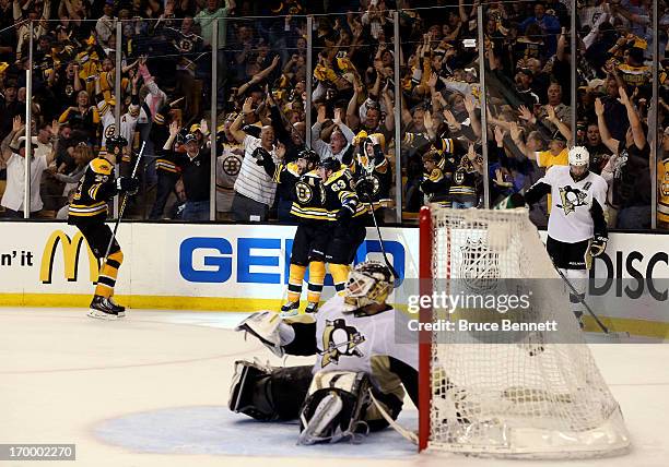 Patrice Bergeron of the Boston Bruins celebrates with Brad Marchand and Zdeno Chara after scoring the game winning goal in double overtime to beat...