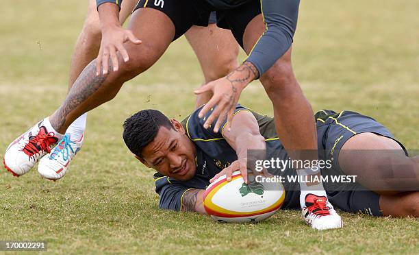 Australian Wallabies fullback Israel Folau presents the ball in a drill during a team training session in Sydney on June 6, 2013. The Wallabies are...