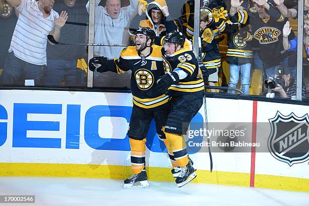 Patrice Bergeron of the Boston Bruins celebrates with Brad Marchand after scoring in overtime against the Pittsburgh Penguins in Game Three of the...