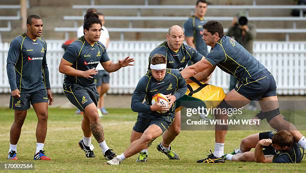 Australian Wallabies flanker Michael Hooper runs with the ball as teammates Will Genia , Saia Fainga'a , Stephen Moore and Rob Simmons support during...