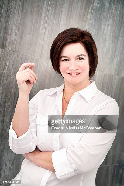 mature woman snapping fingers in front of tile wall - met de vingers knippen stockfoto's en -beelden