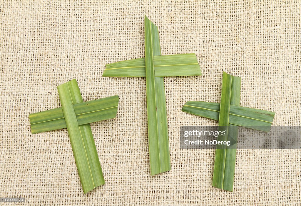 Three palm crosses on a burlap background