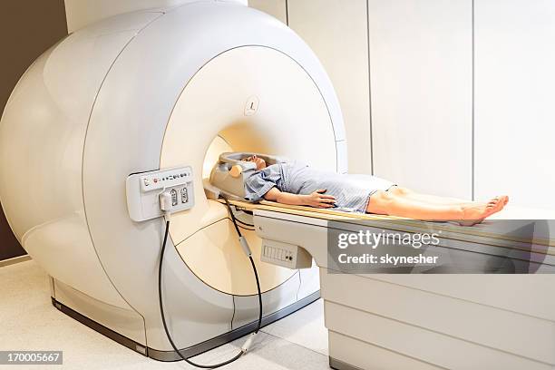 frau, die eine medizinische untersuchung über magnetresonanztomographie. - pet scan machine stock-fotos und bilder