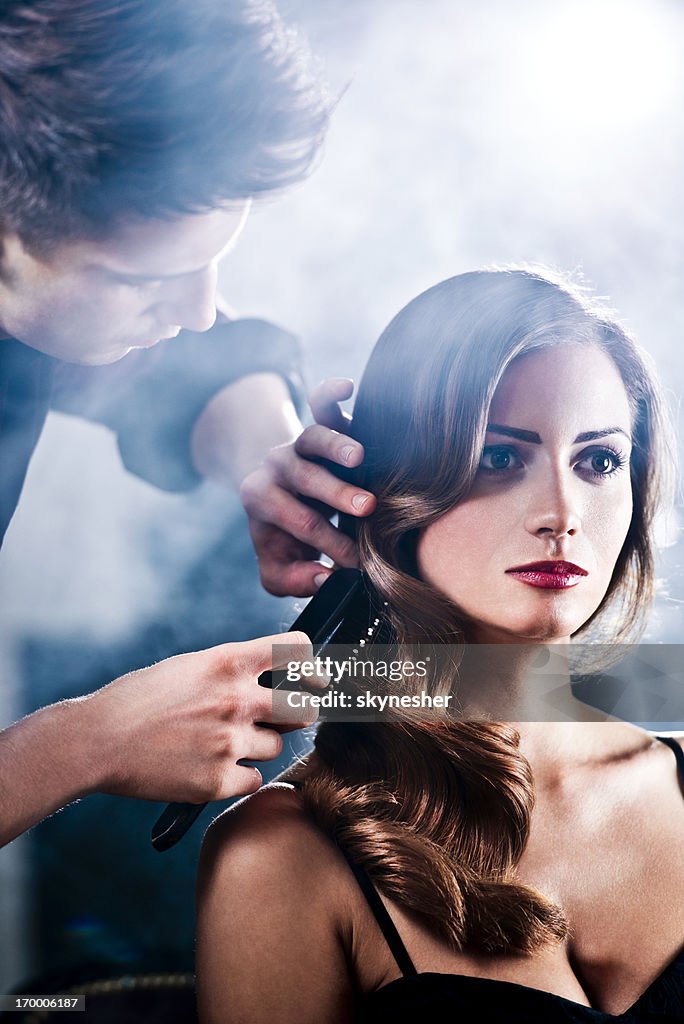 Hairdresser making glamorous retro hairstyle.