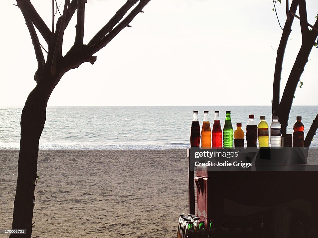 Sun shining through bottles of drink at the beach