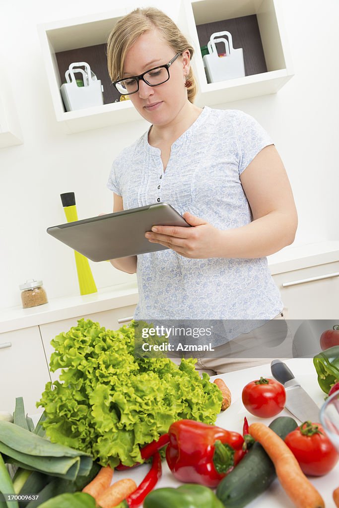 A young woman reading recipe.