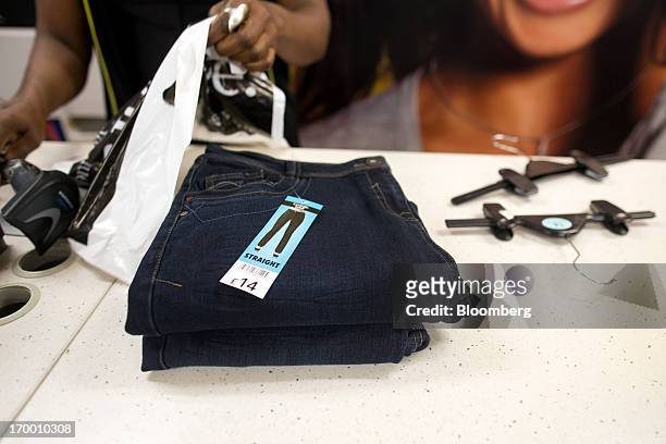 Pile of ladies straight cut George branded denim jeans, manufactured in Bangladesh for the Asda supermarket chain, the U.K. Retail arm of Wal-Mart...