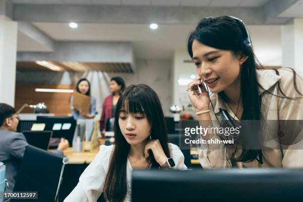 a female colleague approaches to assist another colleague. she may be offering help, sharing information, or collaborating with the colleague to address a particular issue. - camera operator stock pictures, royalty-free photos & images