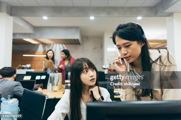 a female colleague approaches to assist another colleague. she may be offering help, sharing information, or collaborating with the colleague to address a particular issue. - camera operator stock pictures, royalty-free photos & images