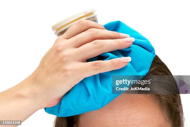 photo of an aching head with ice bag - women injury stockfoto's en -beelden
