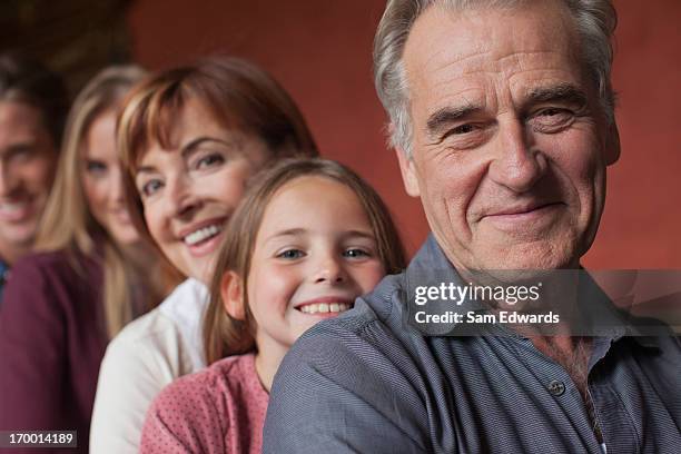 porträt eines lächelnden großeltern mit enkelin - familie mit mehreren generationen stock-fotos und bilder