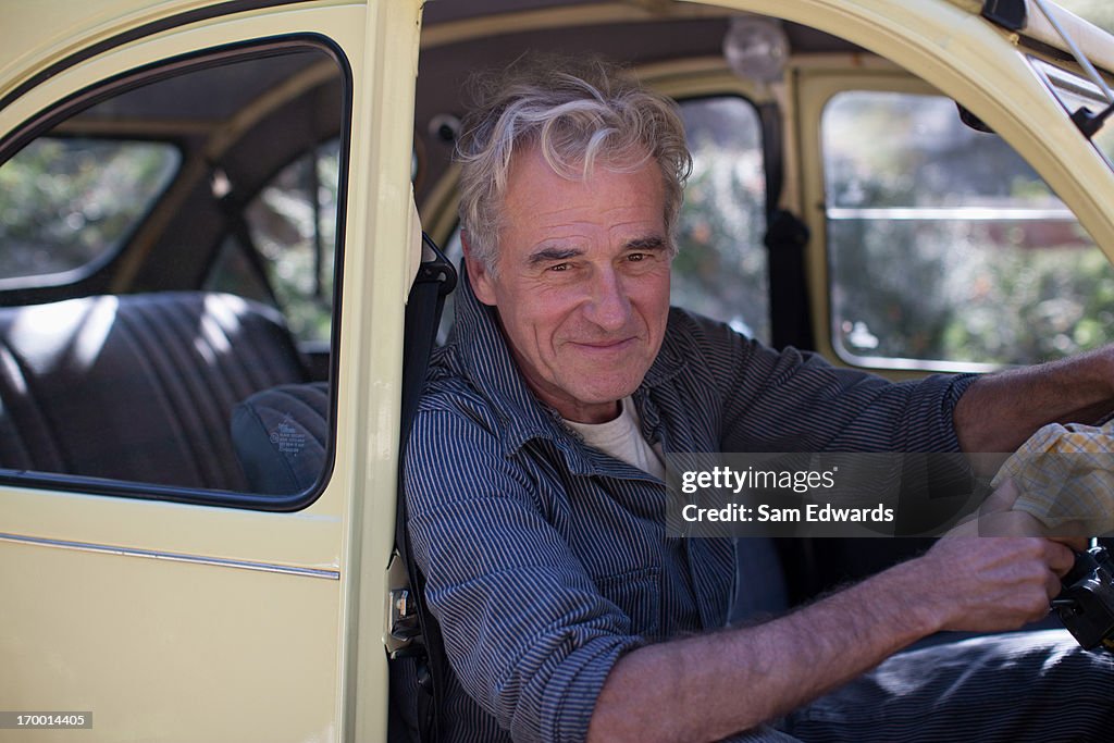 Ritratto di sorridente uomo anziano in auto porta