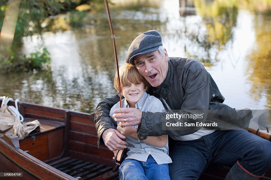 Grandfather and grandson fishing in boat