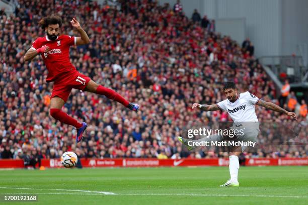Emerson Palmieri of West Ham United shoots under pressure from Mohamed Salah of Liverpool during the Premier League match between Liverpool FC and...