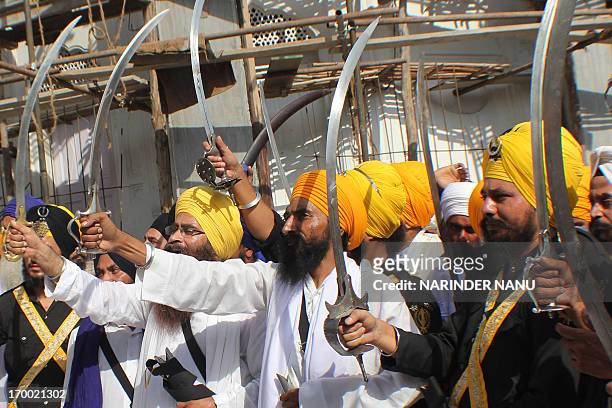 Activists from various radical Sikh organisations hold swords in support of Sikh leader Sant Jarnail Singh Bhindranwale and Khalistan, the name given...