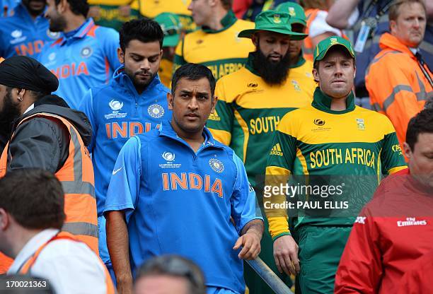 India's Mahendra Sing Dhoni and South Africa's AB de Villiers lead their teams out for the start of the 2013 ICC Champions Trophy cricket match...