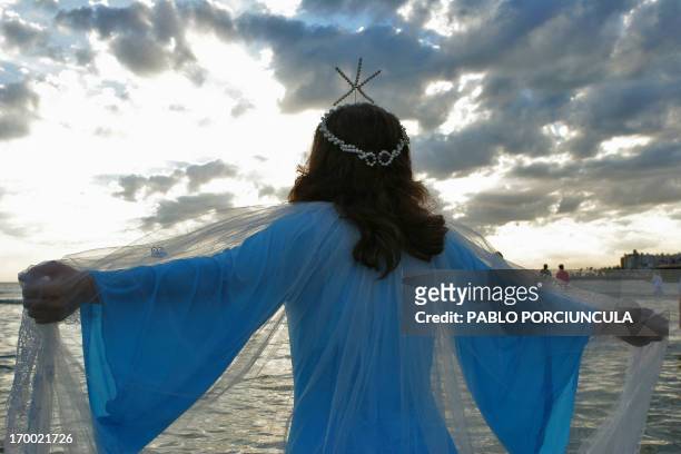 Woman meditates before offering flowers to Iemanja, the Goddess of the Sea of the Afro-American religion Umbanda, 02 February 2006 at a beach in...