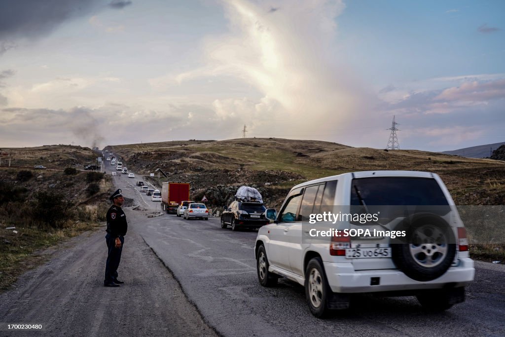 A line of cars, many loaded with personal belongings seen...