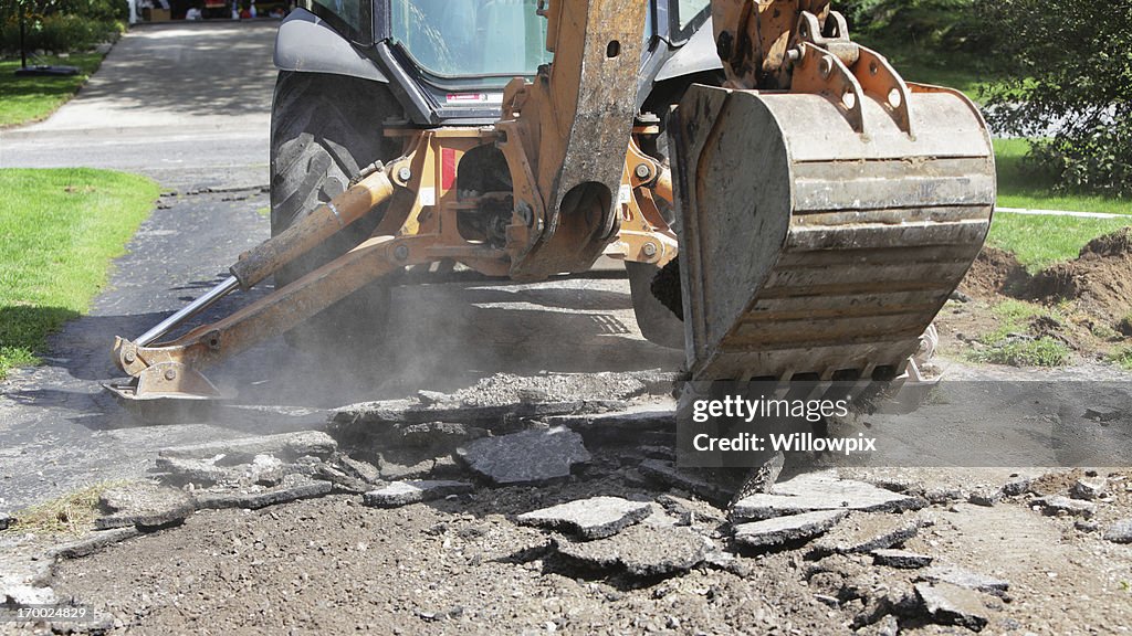 Backhoe Excavator Demolishing Old Residential Driveway