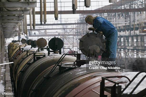 Worker closes a railway tank loaded with oil at the refinery of Canadian oil company Hurricane Kumkol Munai December 21, 2002 in Chemkent,...