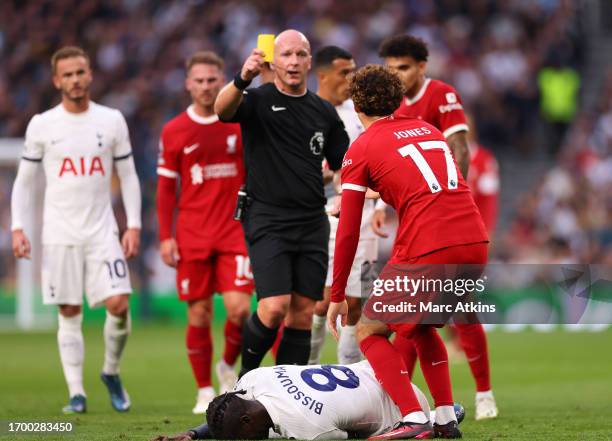 Simon Hooper shows Curtis Jones of Liverpool a yellow card of a foul on Yves Bissouma of Tottenham Hotspur later upgraded to red after a VAR review...