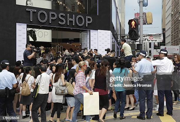 Media and shoppers crowd outside the new Topshop store in Hong Kong, just prior to the store being opened to the public, on June 6, 2013 in Hong...