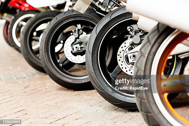 fila di assortimento di una motocicletta ruote su una superficie di mattoni - motocicletta foto e immagini stock