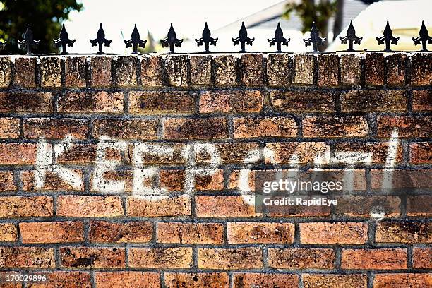 unfriendly graffiti on wall with spiked top says "keep out!" - keep out sign stock pictures, royalty-free photos & images