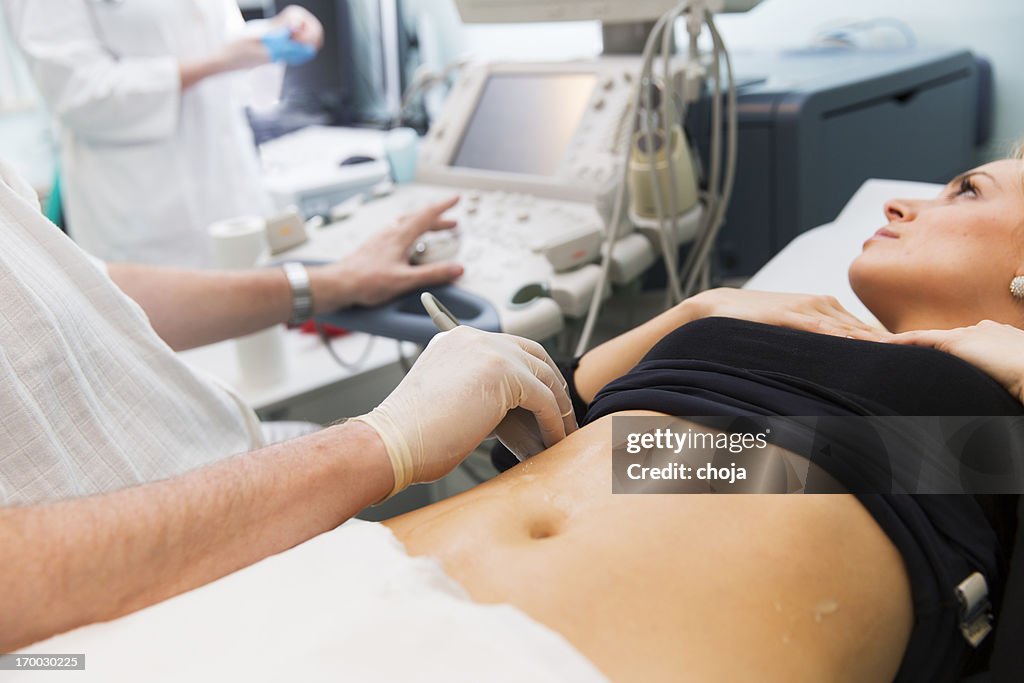 Doctor is giving beautiful young patient an ultra sound