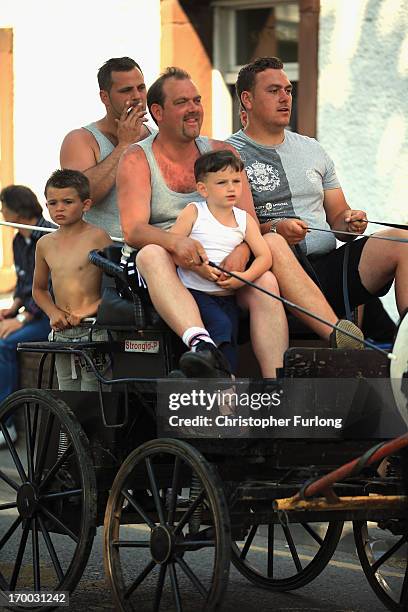 Traveller men and boys sit on the banks of the River Eden to watch horses being washed during the Appleby Horse Fair on June 6, 2013 in Appleby,...