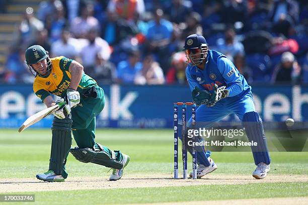 De Villiers of South Africa plays to the legside as wicketkeeper MS Dhoni of India looks on during the Group B ICC Champions Trophy match between...