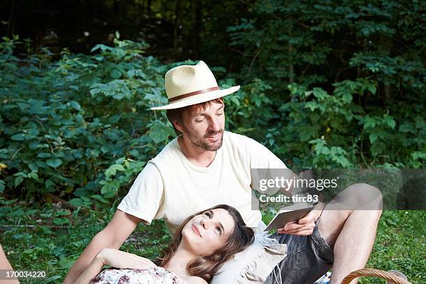 young couple outdoors having picnic on blanket - poetry stock pictures, royalty-free photos & images