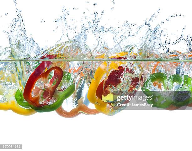 fresh pepper slices splash-down into cool water - pepper spray stockfoto's en -beelden
