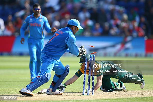 De Villiers of South Africa narrowly makes his ground as MS Dhoni of India breaks the wickets during the Group B ICC Champions Trophy match between...