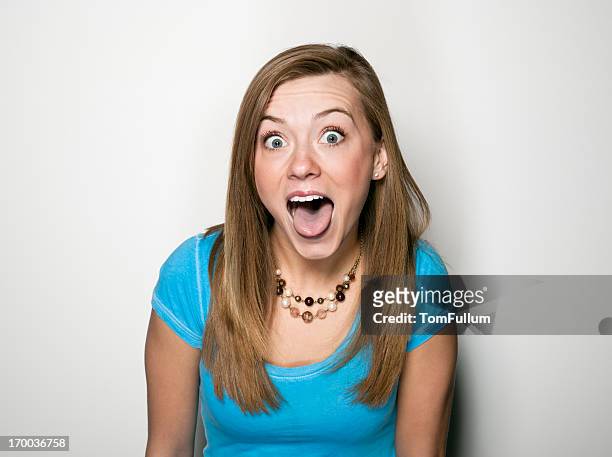 young woman making a face - blonde girl sticking out her tongue stock pictures, royalty-free photos & images