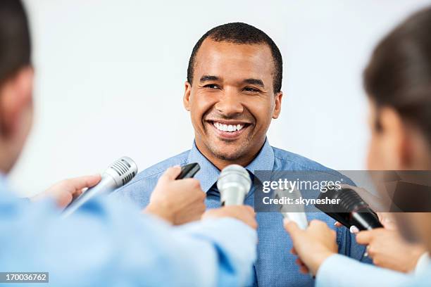 männliche executive, hinterfragt zu werden, von journalisten. - african american interview stock-fotos und bilder