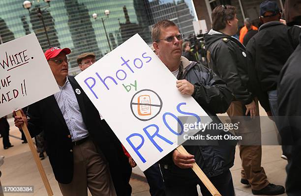 Demonstrators, including union members, reporters, and photographers march outside the offices of the Chicago Sun-Times protesting the newspapers...