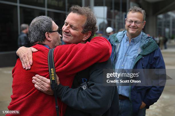 Former Chicago Sun-Times photographers Scott Stewart , Rich Chapman , and Matt Marton greet each other following a demonstration outside the offices...