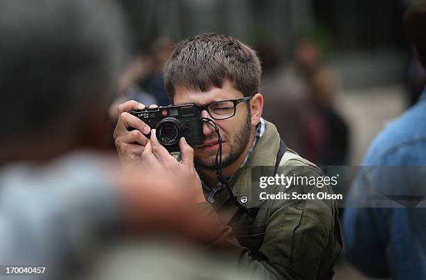 Former Chicago Sun-Times photographer Andrew Nelles shoots pictures of his former colleagues during a demonstration outside the offices of the...
