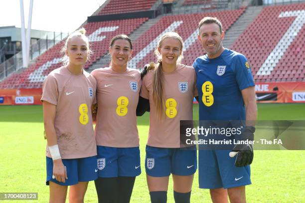 Ellie Roebuck, Mary Earps, Hannah Hampton of England and goalkeeping coach Darren Ward pose for a photo during a training session at Stadium...