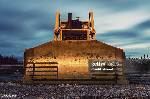 bulldozer in der dämmerung - bulldozer stock-fotos und bilder
