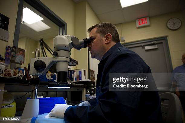 Die Finishing Specialist Dennis Flaherty inspects dies used to strike coins are inspected under a microscope at the United States Mint at West Point...
