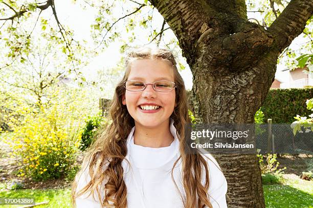 prima comunione ragazza in giardino - prima comunione foto e immagini stock