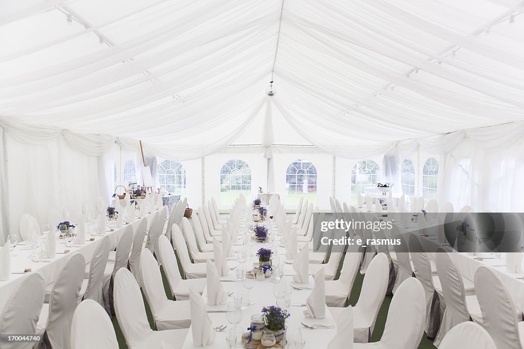 Three white banquet tables with white settings