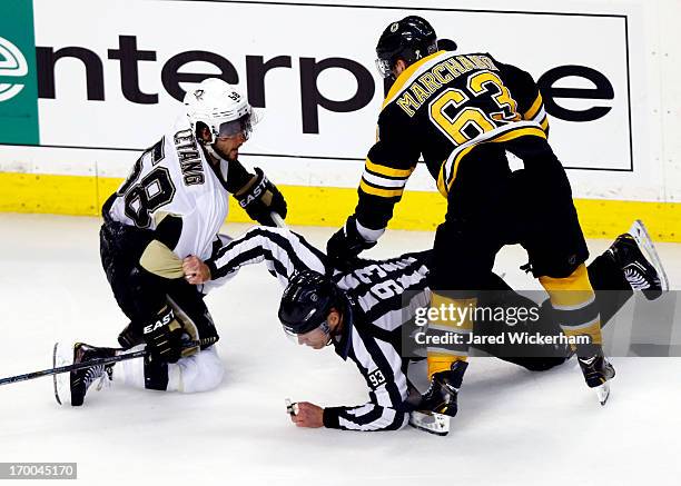 Brad Marchand of the Boston Bruins and Kris Letang of the Pittsburgh Penguins are separated by linesman Brian Murphy during Game Three of the Eastern...