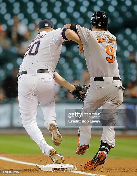 Bud Norris of the Houston Astros beats Nate McLouth of the Baltimore Orioles to the bag for the out in the first inning at Minute Maid Park on June...