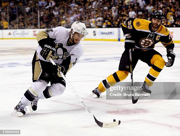 Chris Kunitz of the Pittsburgh Penguins skates with the puck as Zdeno Chara of the Boston Bruins defends during Game Three of the Eastern Conference...