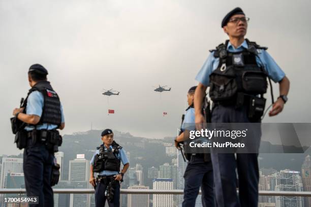 Police officers standing guard in front of Helicopters operated by the Hong Kong Government Flying Service with the National Flag of China and the...