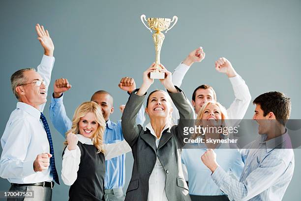 cheerful group of businesspeople winning the cup. - trophy award stock pictures, royalty-free photos & images
